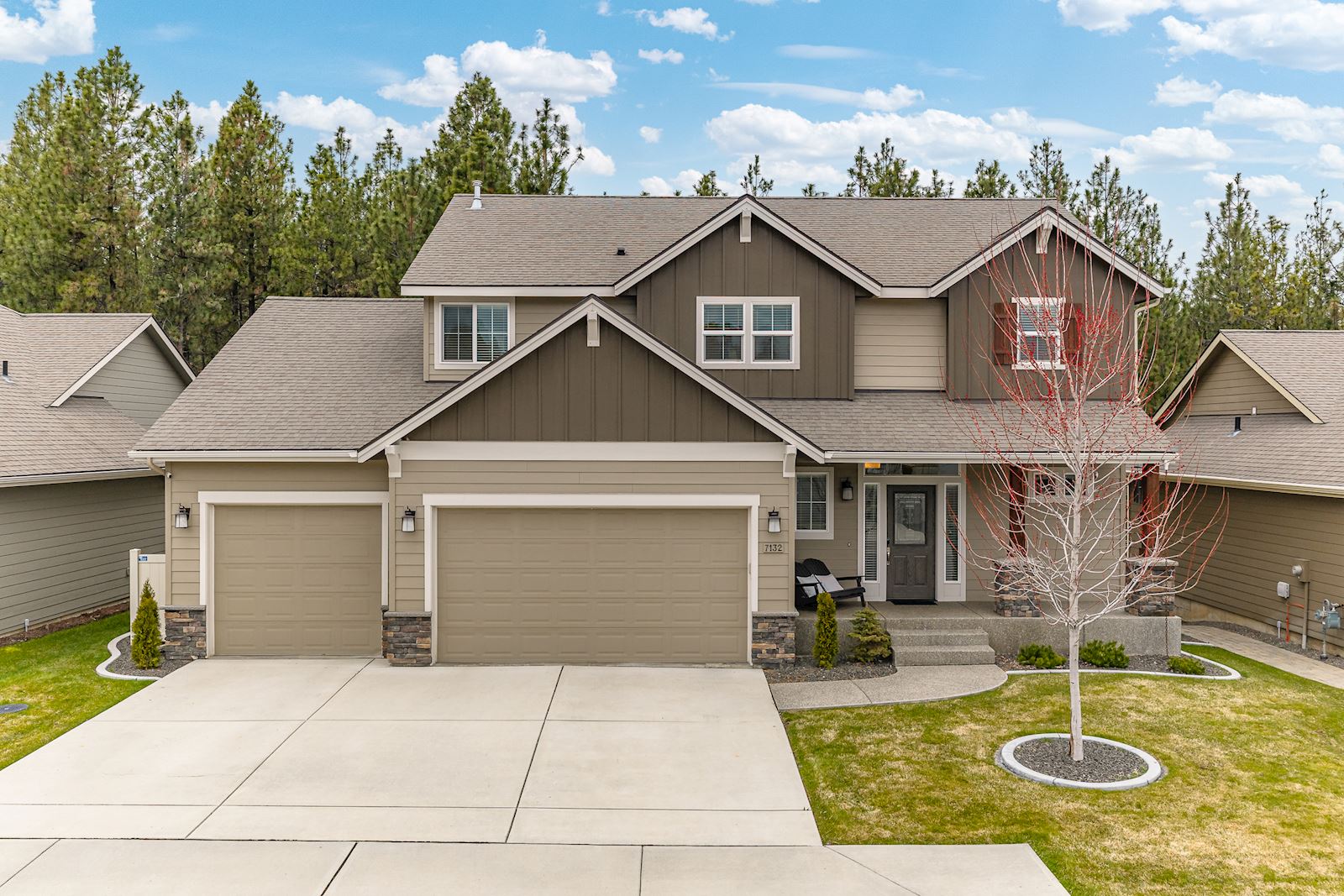Front exterior of 7132 S Pheasant Ridge Dr in Eagle Ridge Spokane WA featuring a beautifully updated 5-bedroom home with a 4-car garage.