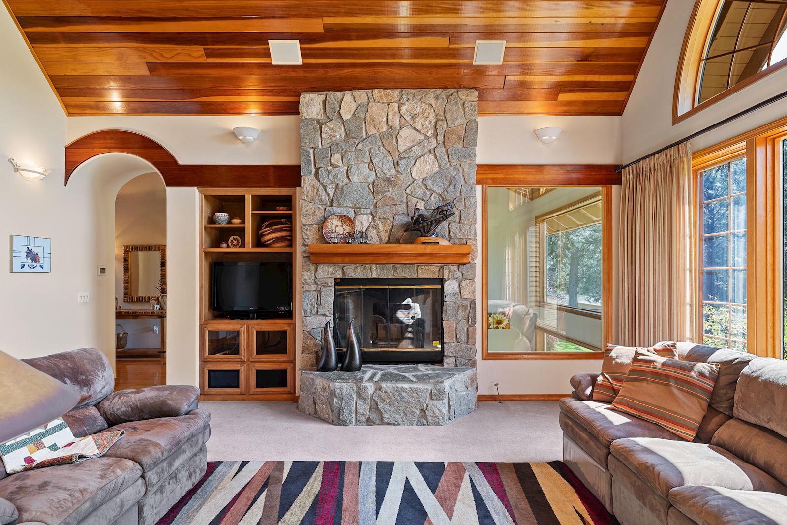 Sophisticated stone-covered gas fireplace in the luxury living room of 13609 W Charles Rd