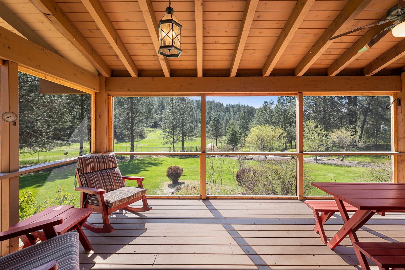 Screened-in wrap-around back porch for year-round entertaining at the Nine Mile Falls luxury estate