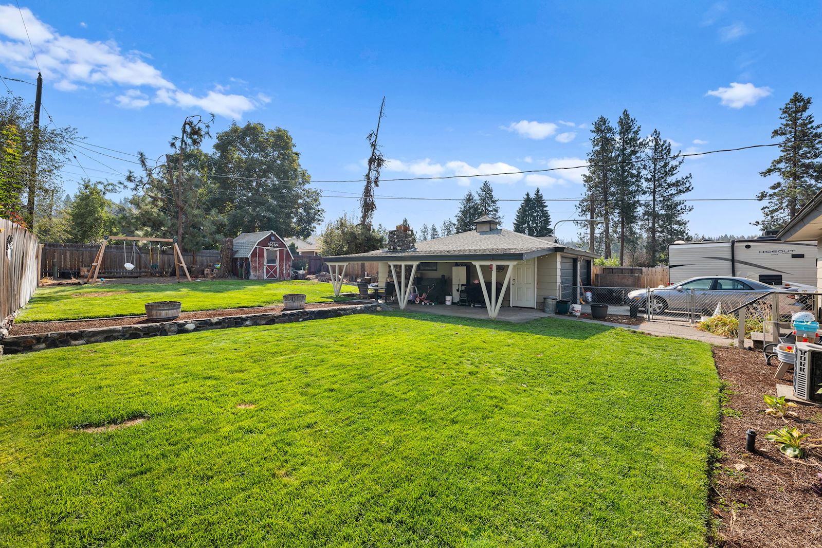 Fully fenced backyard with lawn and shed at 6516 N Hartley St in North Spokane WA 99208. Real estate listing by Team Dailey | John L. Scott Real Estate.