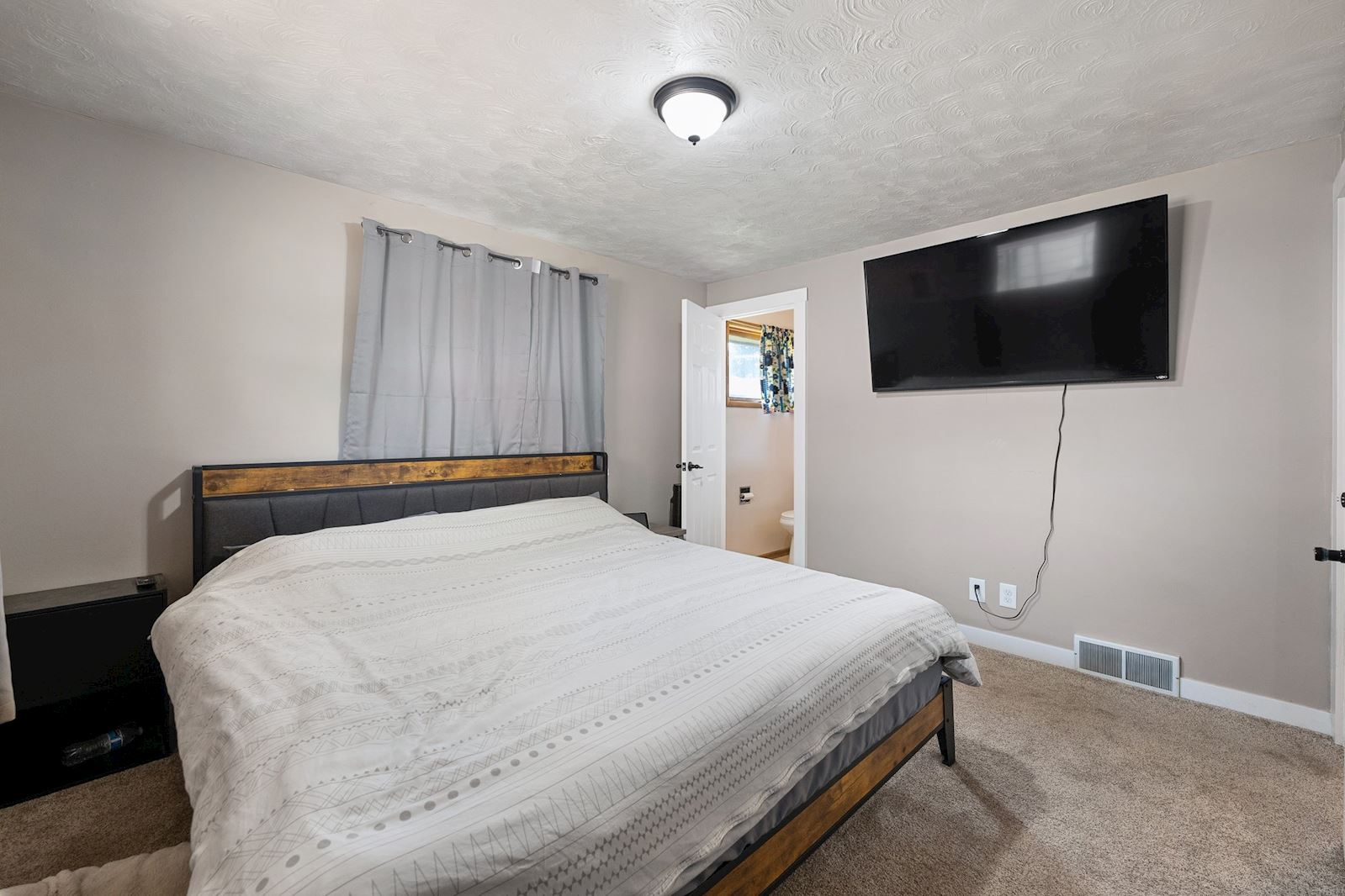 Primary bedroom with ensuite half bath at 6516 N Hartley St in North Spokane WA 99208. Real estate listing by Team Dailey | John L. Scott Real Estate.