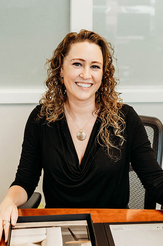 Mira Gregory seating on a desk