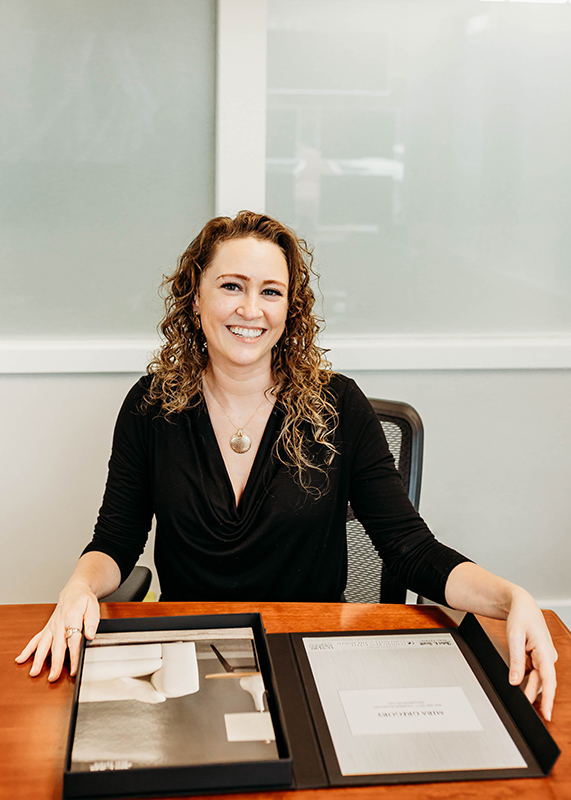 Mira Gregory seating on a desk