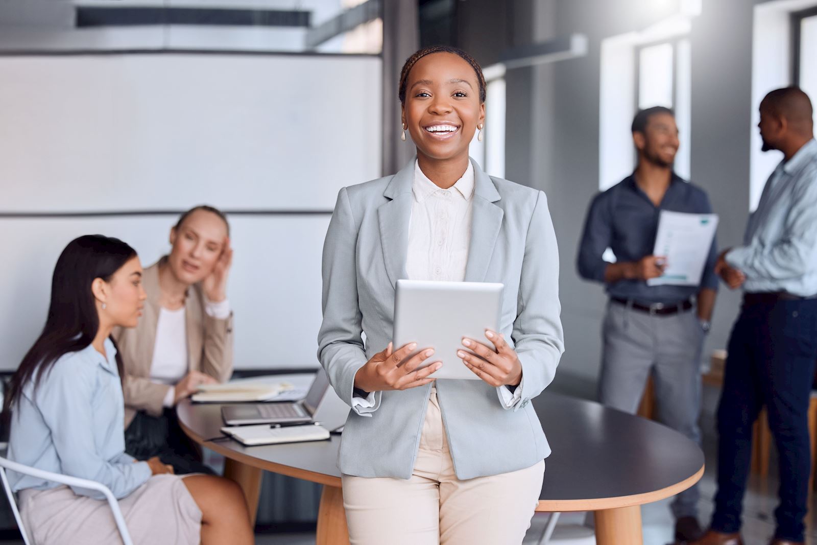 Woman Standing int front of a conference room smiling; Commercial Real Estate Investor